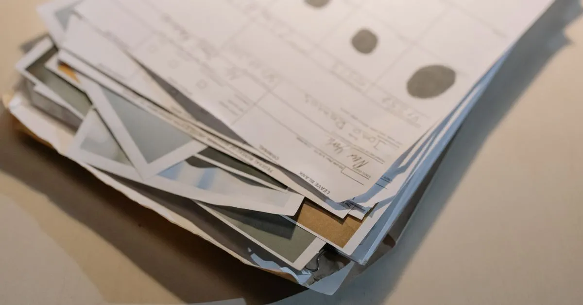 Stack of printed document pages on a desk, the kind that needs page numbers added to the PDF