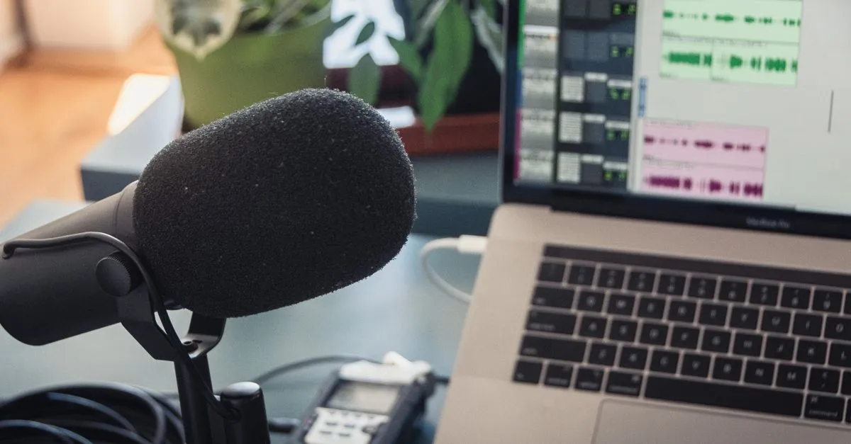 Audio editing waveform on a laptop screen next to headphones, used to cut and trim an MP3 file