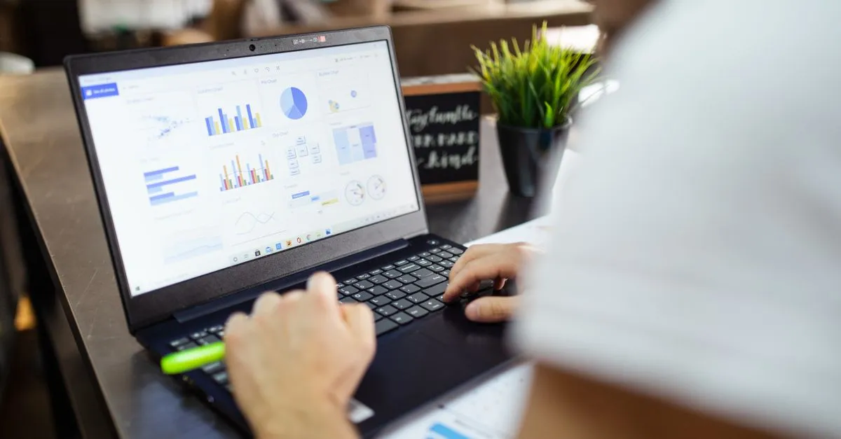 Founder at a laptop reviewing startup burn rate and cash runway numbers at a desk