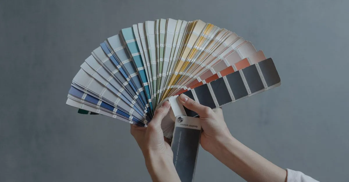 Color palette swatches and paint samples spread across a designer's desk