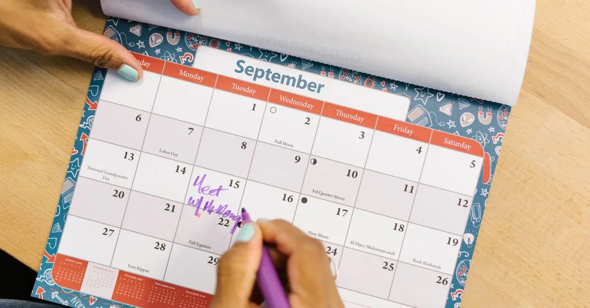 Paper calendar planner on a desk used for counting days between two dates
