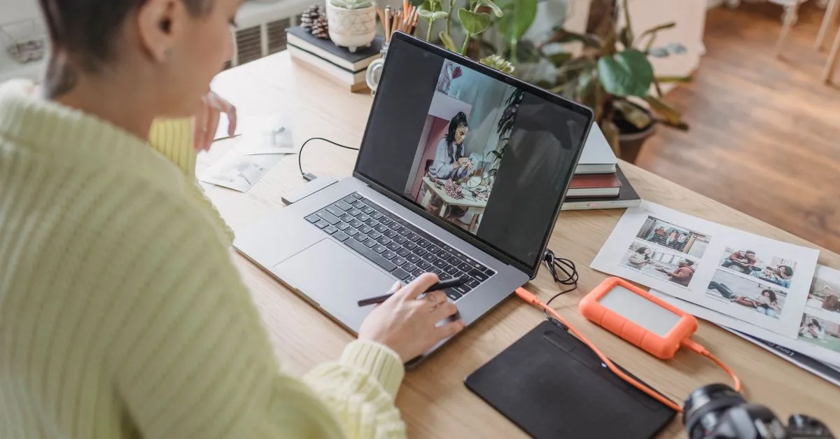 Photographer editing and watermarking photos on a laptop in a studio